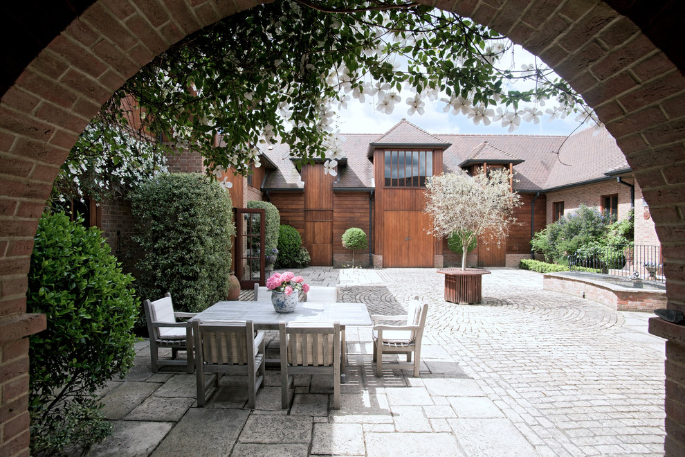 Classic courtyard patio in Sussex with natural stone paving and no cover.