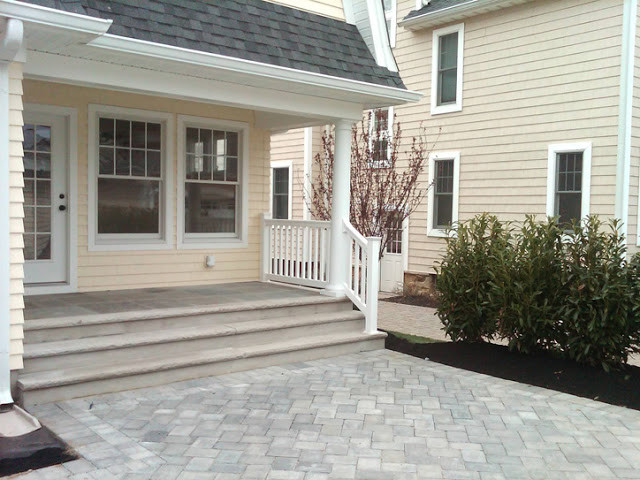 Photo of a medium sized front patio in New York with natural stone paving and no cover.