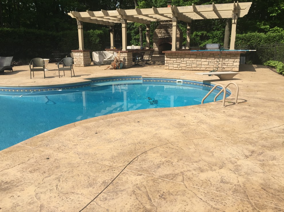 Design ideas for a large back patio in Detroit with stamped concrete.
