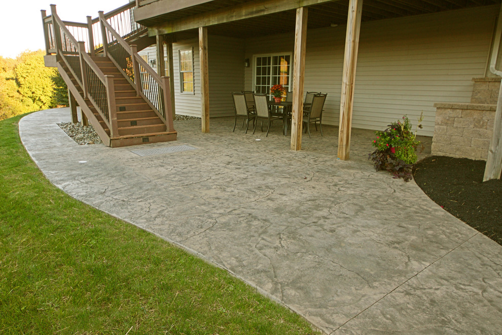 Immagine di un patio o portico minimalista di medie dimensioni e dietro casa con cemento stampato
