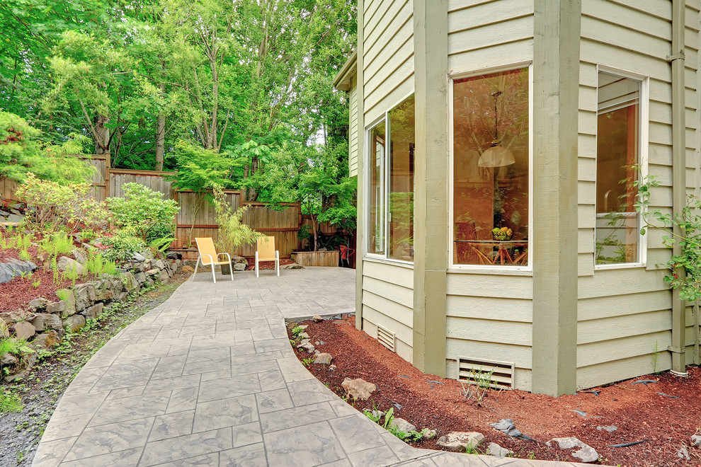 Imagen de patio clásico de tamaño medio en patio trasero y anexo de casas con brasero y suelo de hormigón estampado
