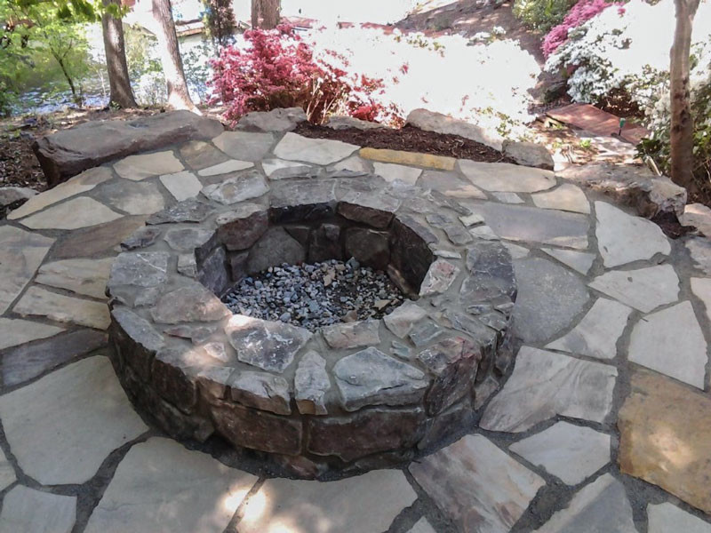 This is an example of a classic patio in Charlotte with a fire feature, natural stone paving and no cover.