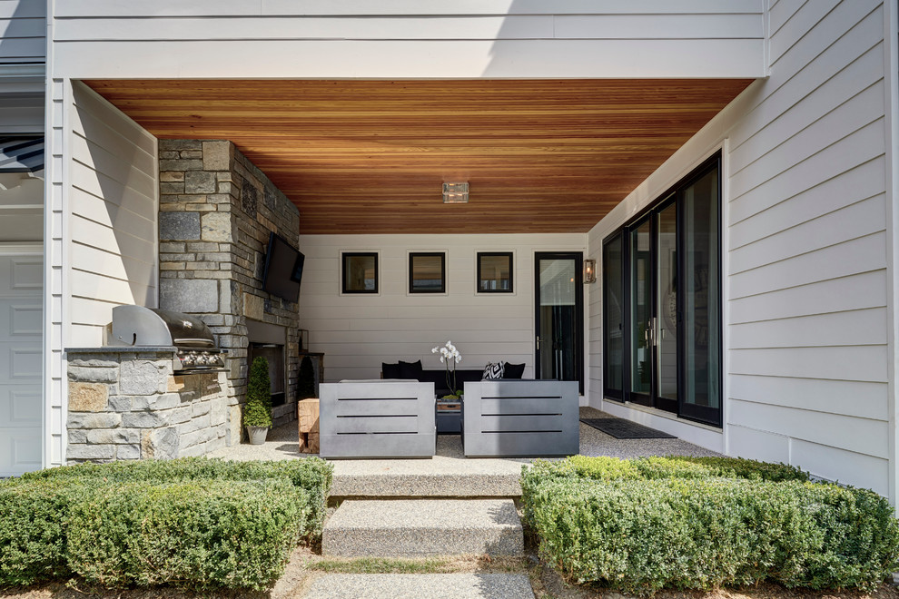 Idée de décoration pour une grande terrasse latérale tradition avec une extension de toiture et un foyer extérieur.