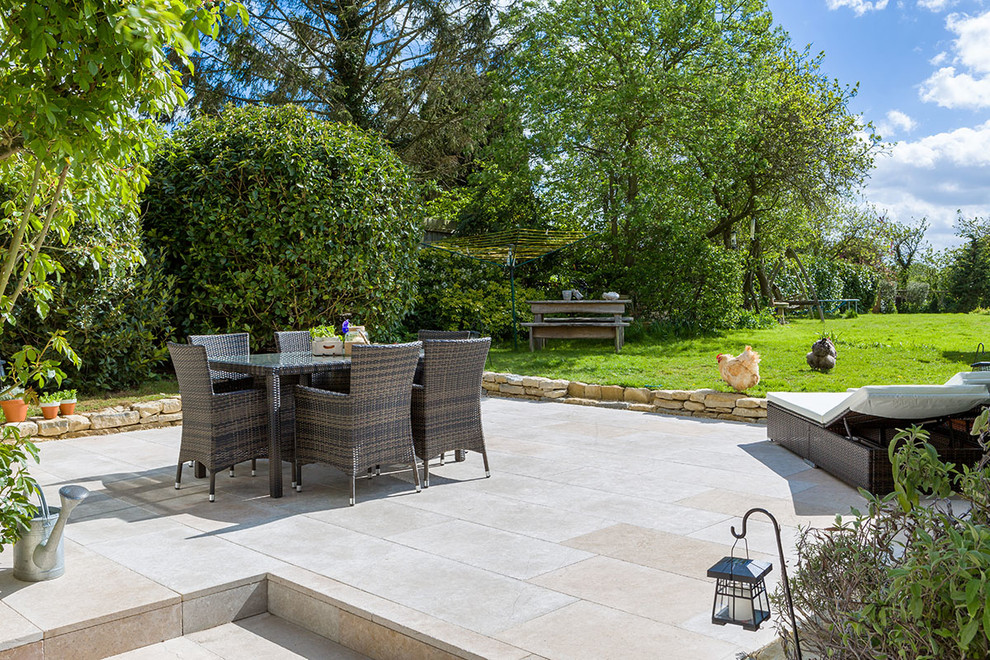 Foto de patio clásico grande sin cubierta en patio trasero con adoquines de piedra natural