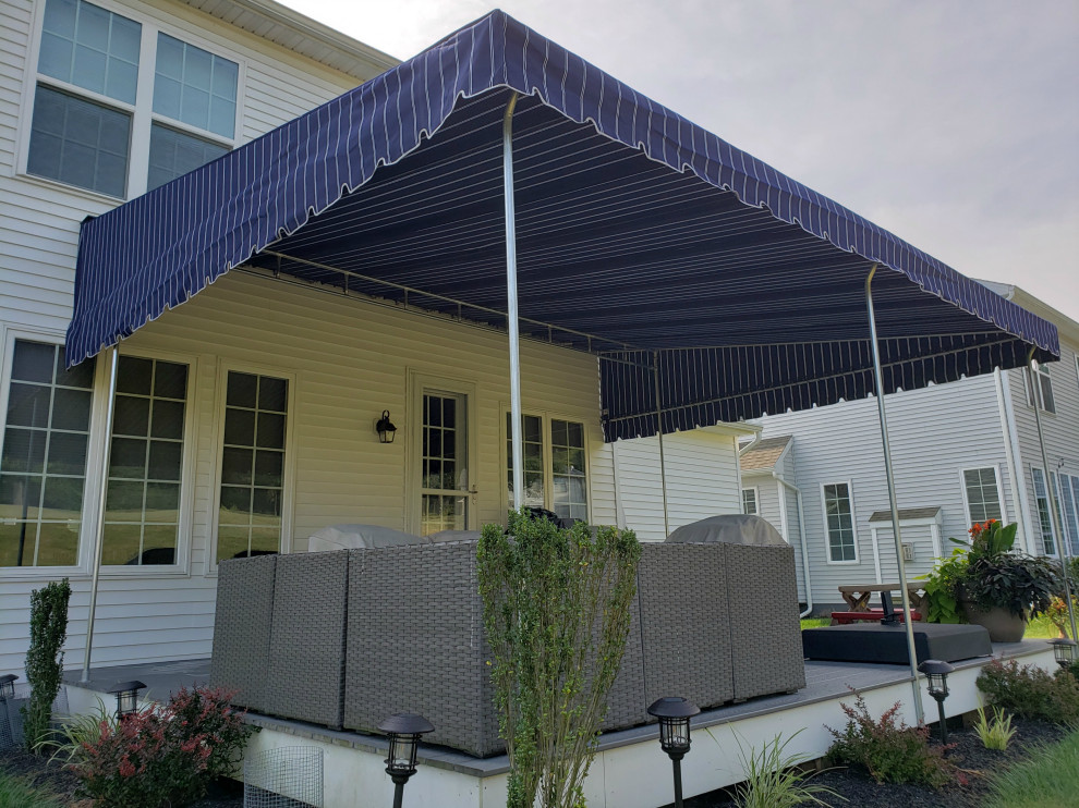 Design ideas for a large classic back patio in Philadelphia with an awning.