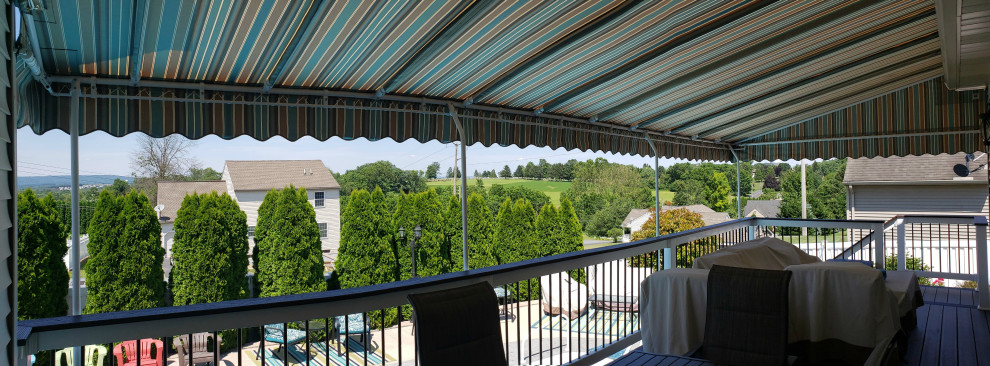 Foto di un grande patio o portico classico dietro casa con un parasole