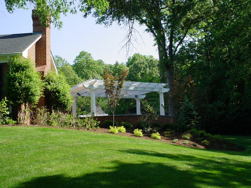 Esempio di un grande patio o portico chic dietro casa con pavimentazioni in mattoni e una pergola