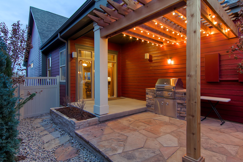 Idee per un patio o portico american style con pavimentazioni in pietra naturale e una pergola