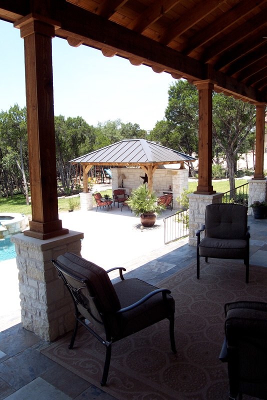 Cette photo montre une terrasse arrière sud-ouest américain de taille moyenne avec une cuisine d'été, des pavés en pierre naturelle et un gazebo ou pavillon.