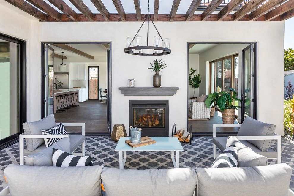 Inspiration for a mediterranean patio in Los Angeles with a fireplace, tiled flooring and a pergola.