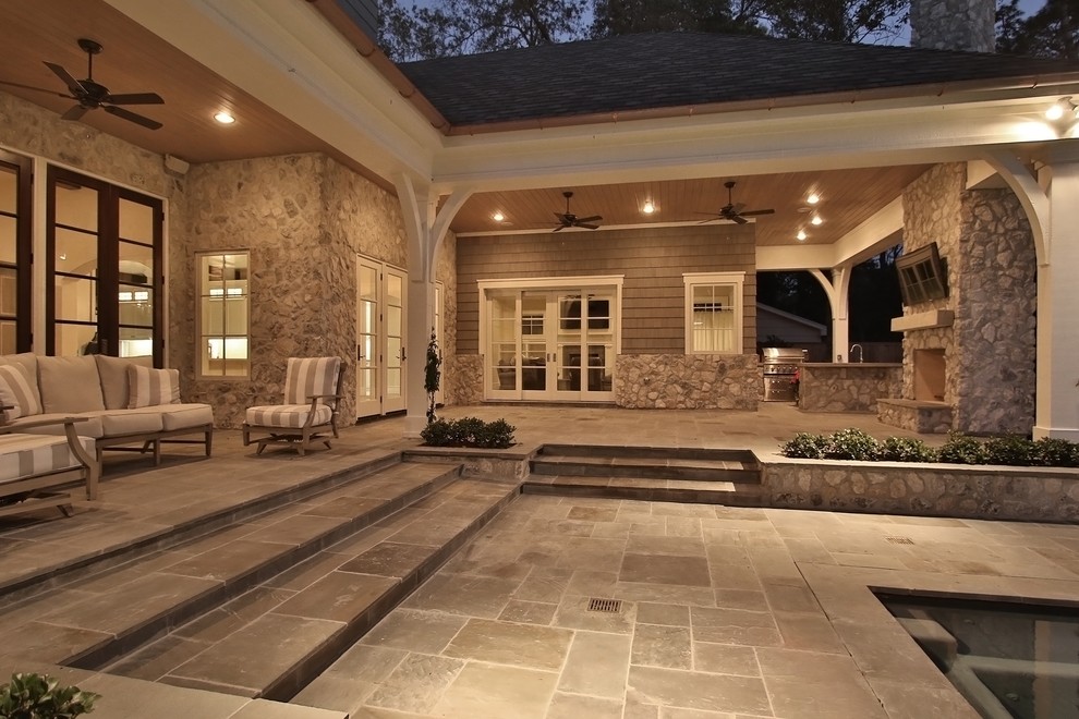 Modelo de patio clásico grande en patio trasero y anexo de casas con brasero y adoquines de piedra natural