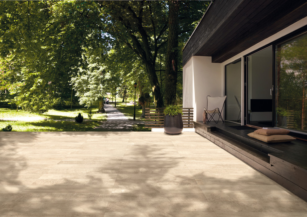 На фото: большой двор на внутреннем дворе в современном стиле с покрытием из плитки без защиты от солнца