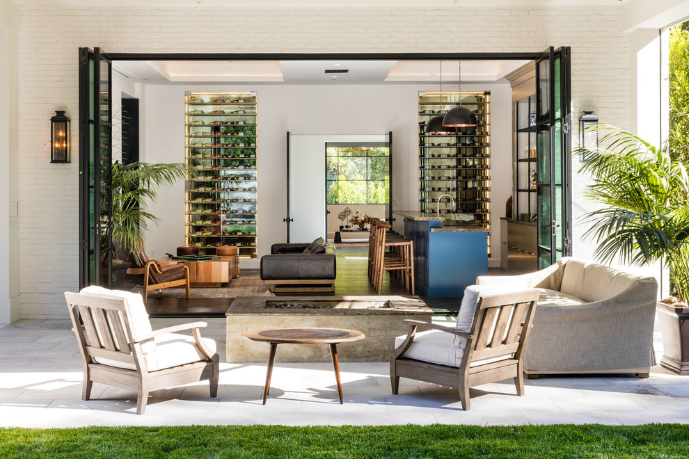 Inspiration for a large contemporary backyard stone patio remodel in Los Angeles with a roof extension