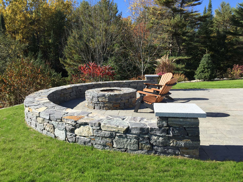 Inspiration for a mid-sized timeless backyard stone patio remodel in Portland Maine with a fire pit and no cover