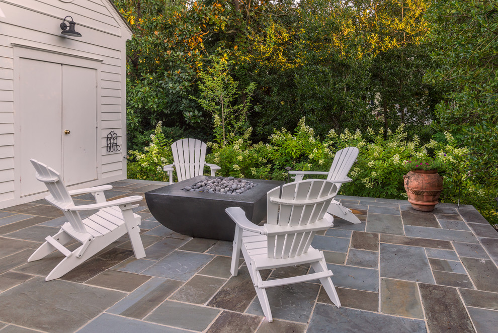 Foto di un piccolo patio o portico minimalista dietro casa con un focolare, pavimentazioni in pietra naturale e nessuna copertura