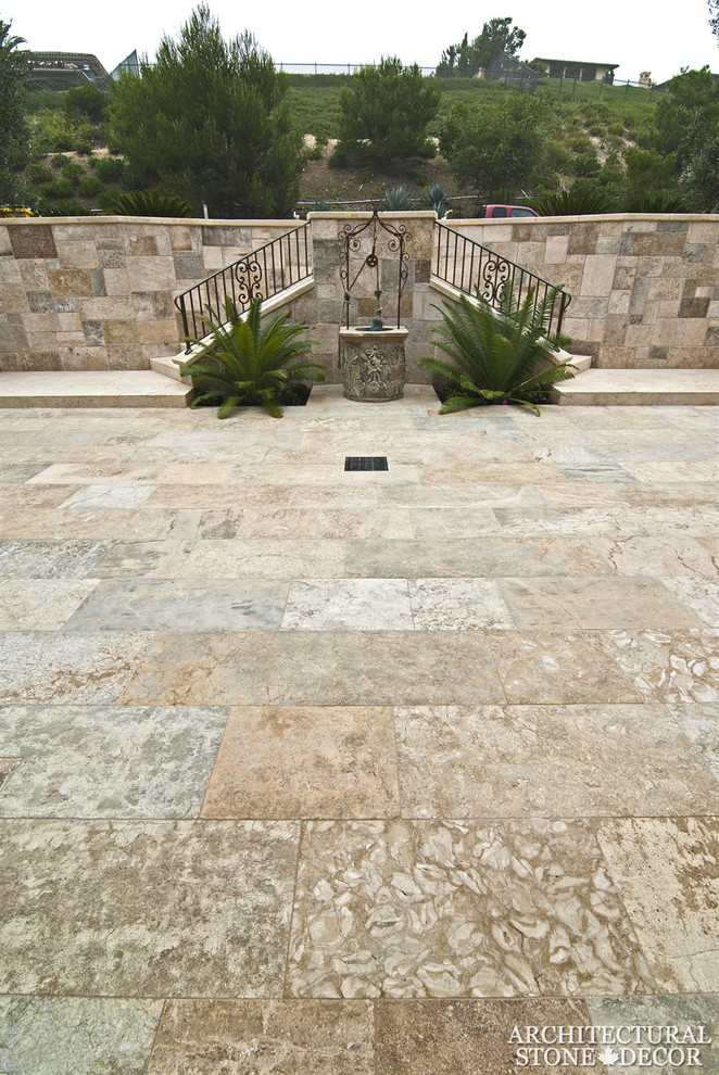 Modelo de patio mediterráneo grande sin cubierta en patio lateral con fuente y adoquines de piedra natural