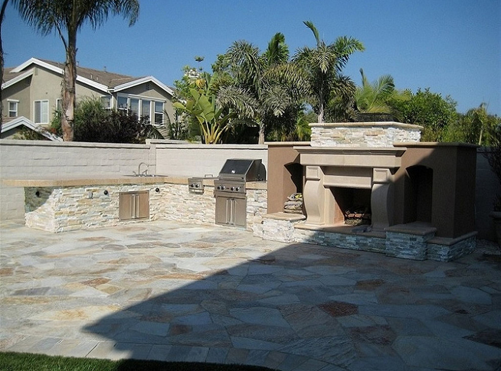 Foto de patio mediterráneo de tamaño medio sin cubierta en patio trasero con cocina exterior y adoquines de piedra natural