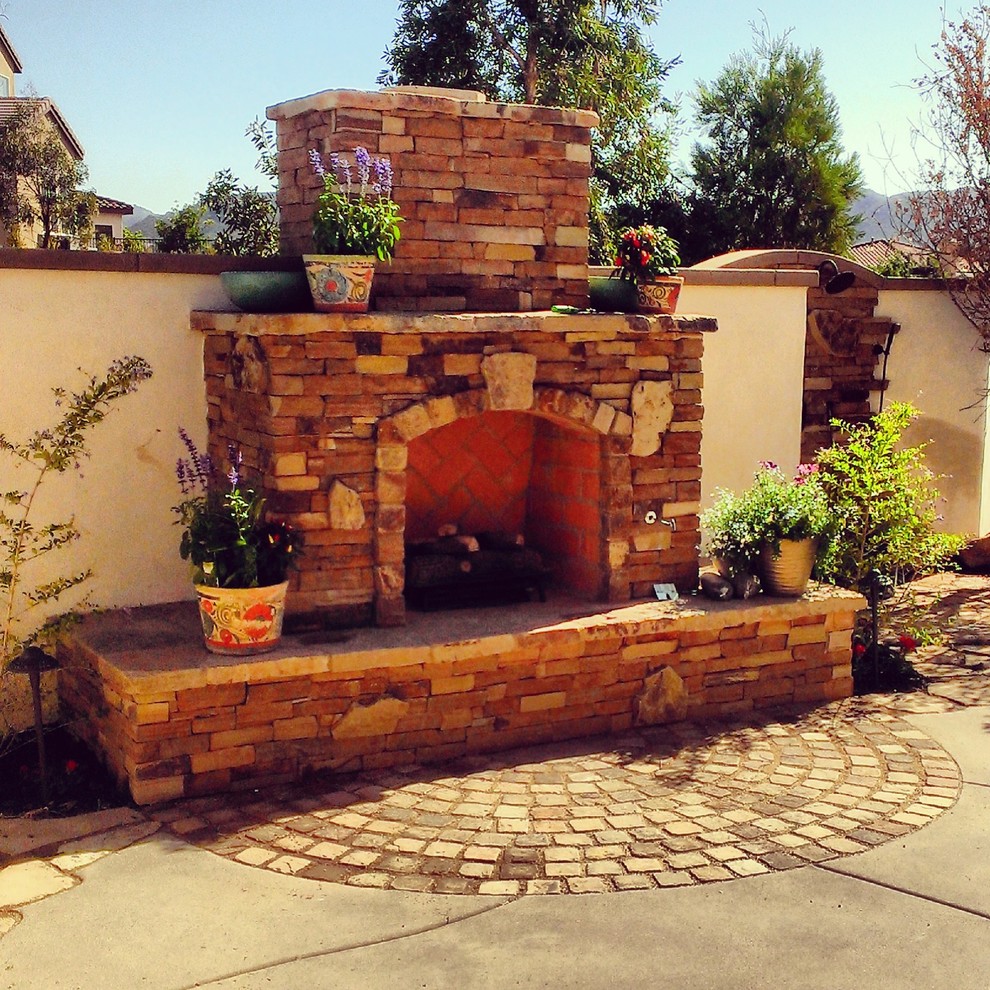 Medium sized mediterranean back patio in San Diego with a fire feature, brick paving and no cover.