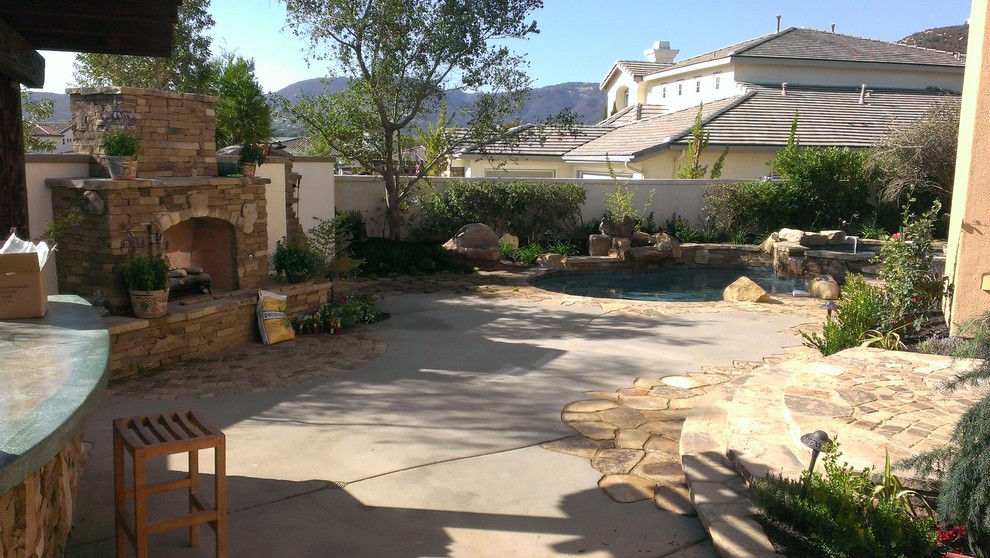 Стильный дизайн: большой двор на заднем дворе в средиземноморском стиле с покрытием из каменной брусчатки и местом для костра без защиты от солнца - последний тренд