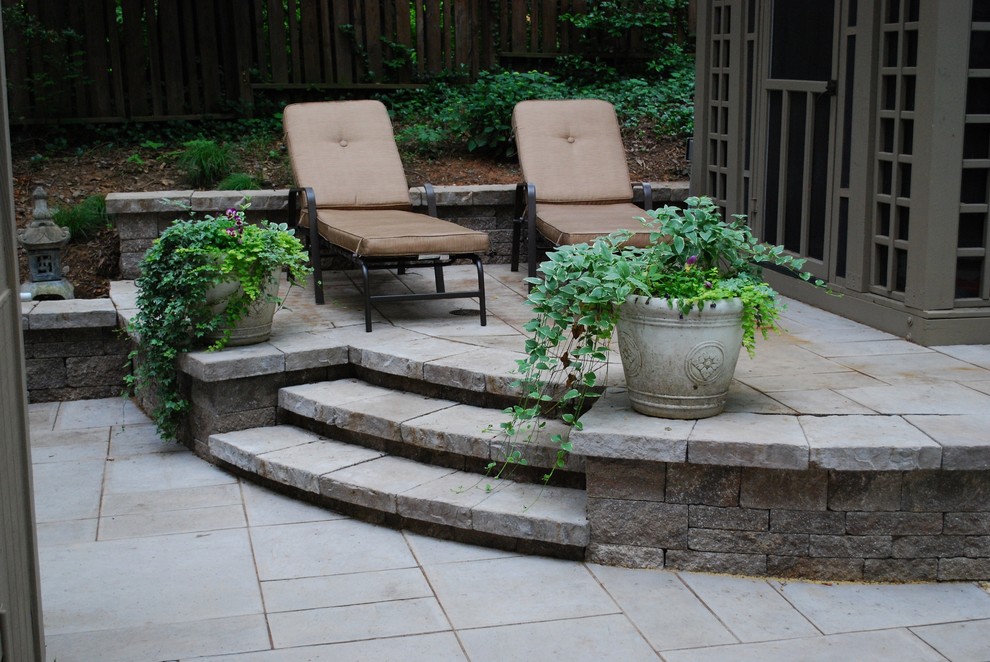 Example of a large classic backyard concrete paver patio design in DC Metro with no cover