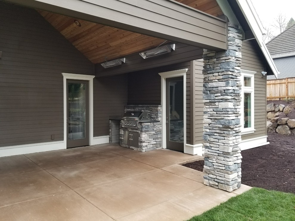 This is an example of a back patio in Portland with an outdoor kitchen and a roof extension.