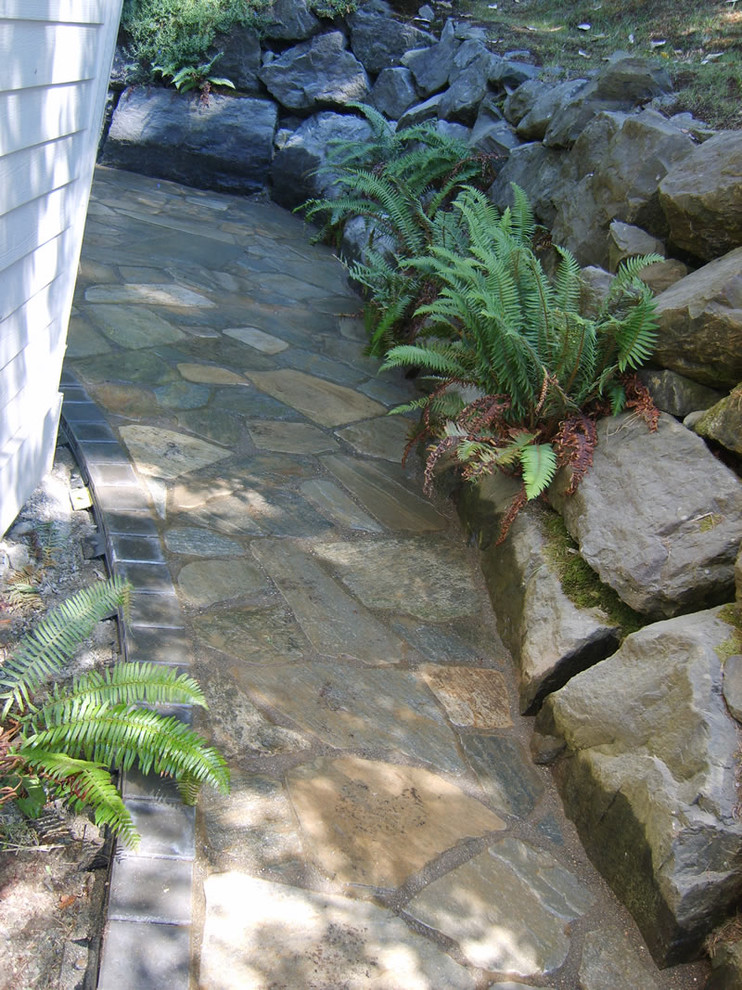 Immagine di un patio o portico tropicale di medie dimensioni e dietro casa con pavimentazioni in pietra naturale