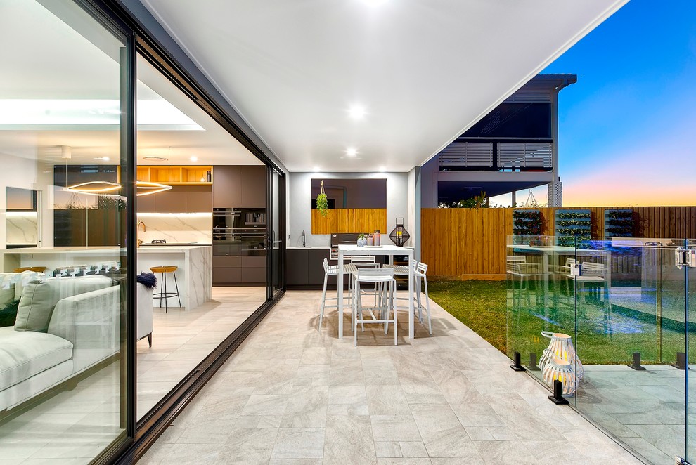 Пример оригинального дизайна: двор на заднем дворе в современном стиле с летней кухней, покрытием из плитки и навесом