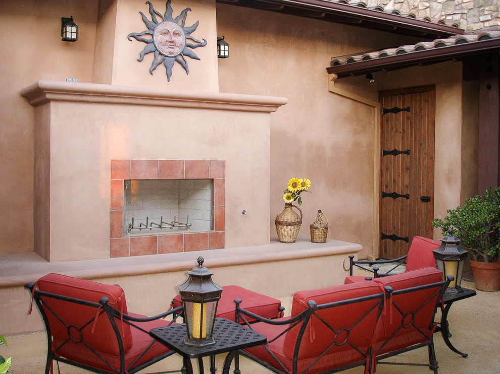 Immagine di un patio o portico american style con un caminetto