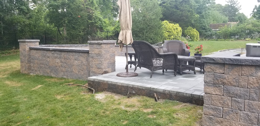 Example of a mid-sized backyard concrete paver patio design in New York with no cover