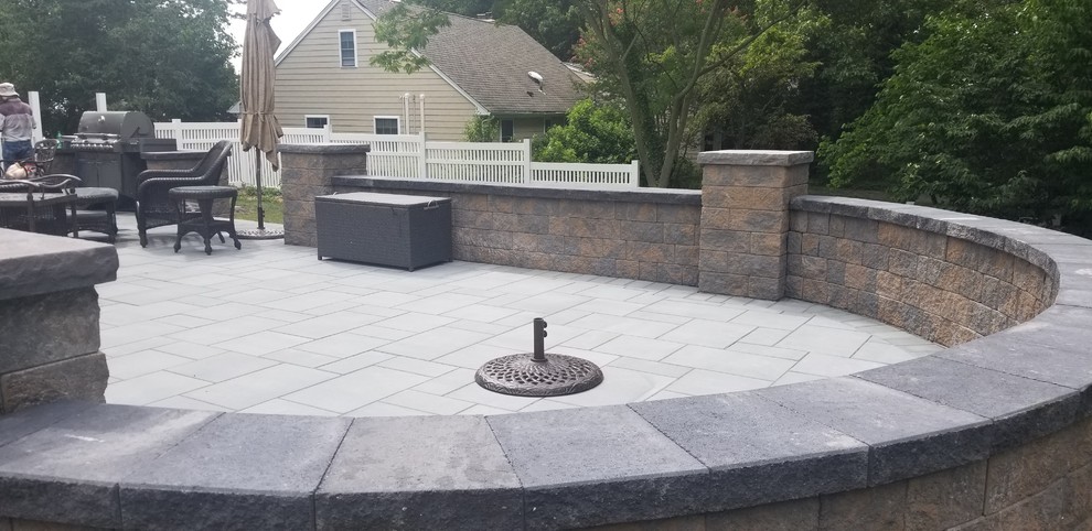 Mid-sized backyard concrete paver patio photo in New York with no cover
