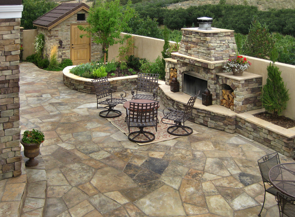 Inspiration pour une grande terrasse arrière traditionnelle avec un foyer extérieur, des pavés en pierre naturelle et aucune couverture.