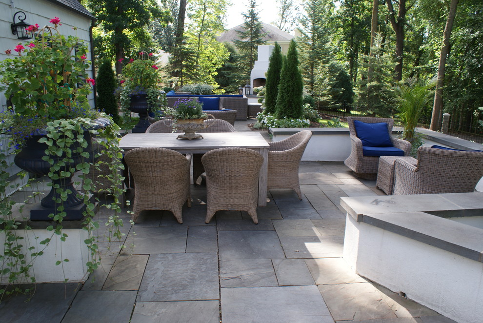 Example of a large classic backyard stone patio design in Minneapolis with no cover