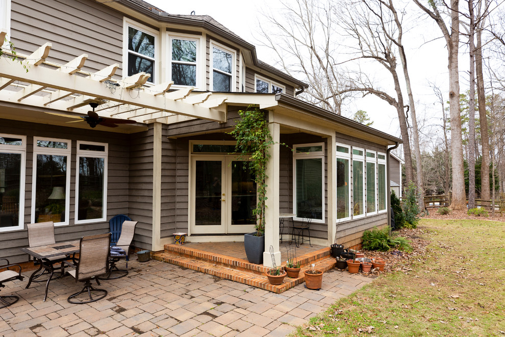 Esempio di un patio o portico minimal di medie dimensioni e dietro casa con un giardino in vaso, pavimentazioni in mattoni e un tetto a sbalzo