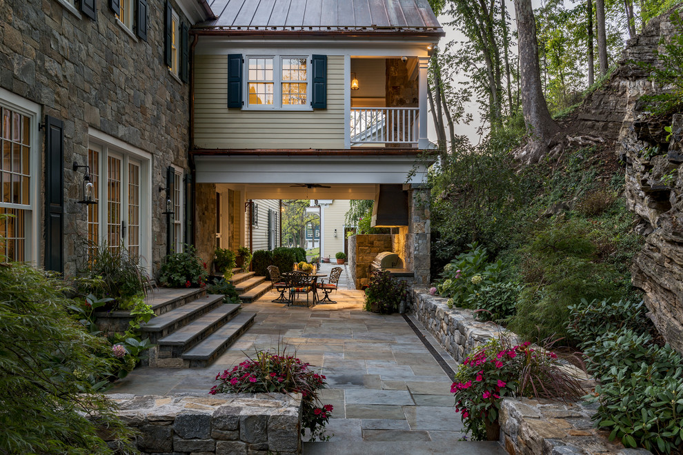 Idee per un patio o portico classico con pavimentazioni in pietra naturale, un tetto a sbalzo e scale