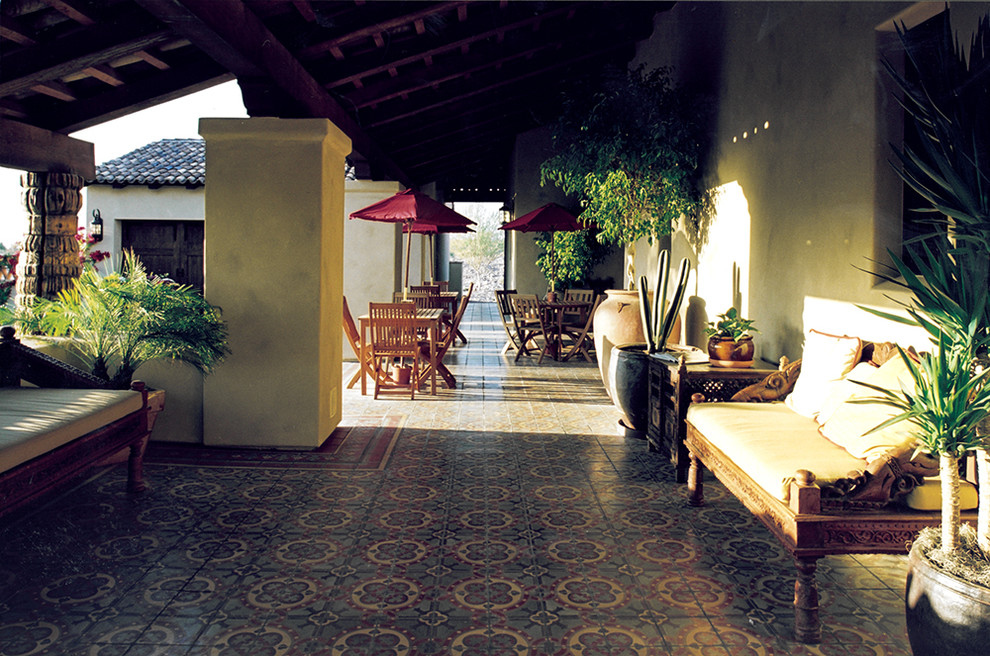 Immagine di un grande patio o portico chic davanti casa con un focolare e un tetto a sbalzo
