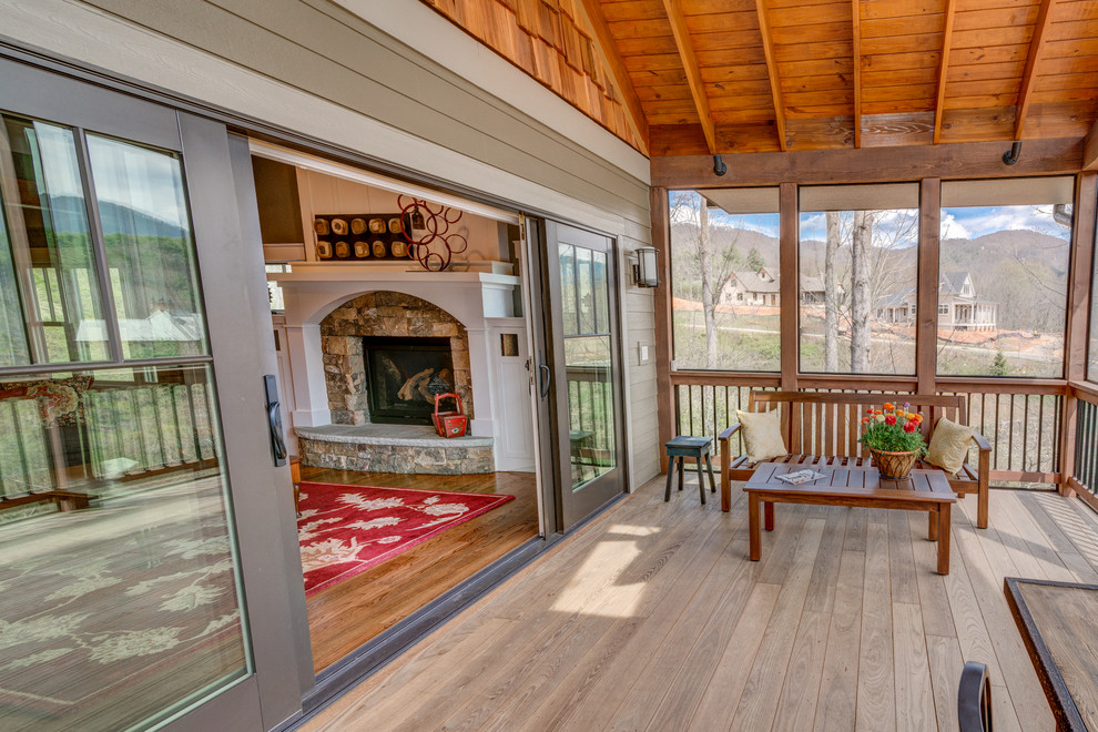 Cette photo montre une terrasse en bois arrière craftsman de taille moyenne avec une extension de toiture.