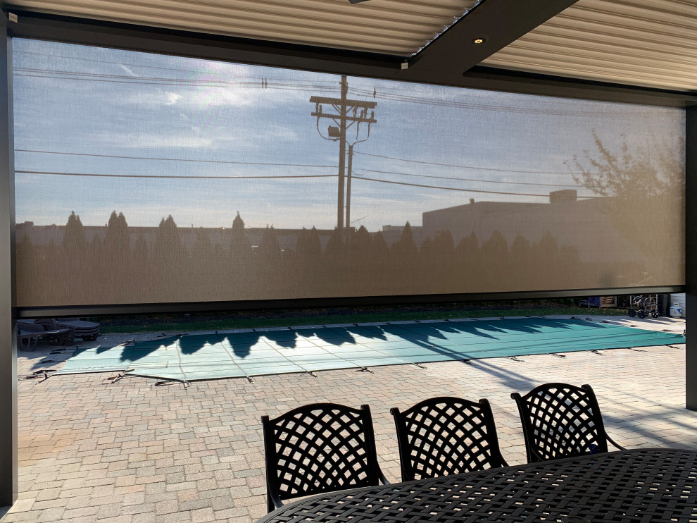 Exempel på en mellanstor modern pool på baksidan av huset, med naturstensplattor
