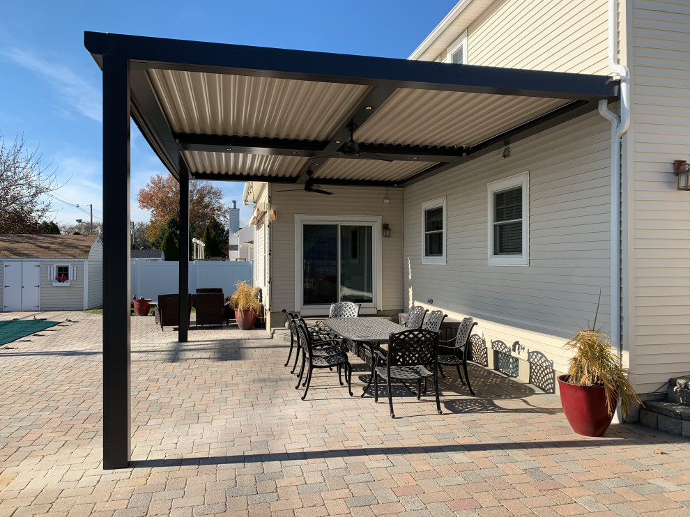 Foto di un patio o portico minimalista di medie dimensioni e dietro casa con pavimentazioni in pietra naturale e una pergola