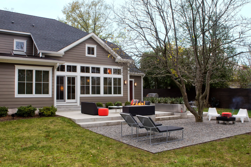 Immagine di un patio o portico minimal dietro casa con un focolare, ghiaia e nessuna copertura