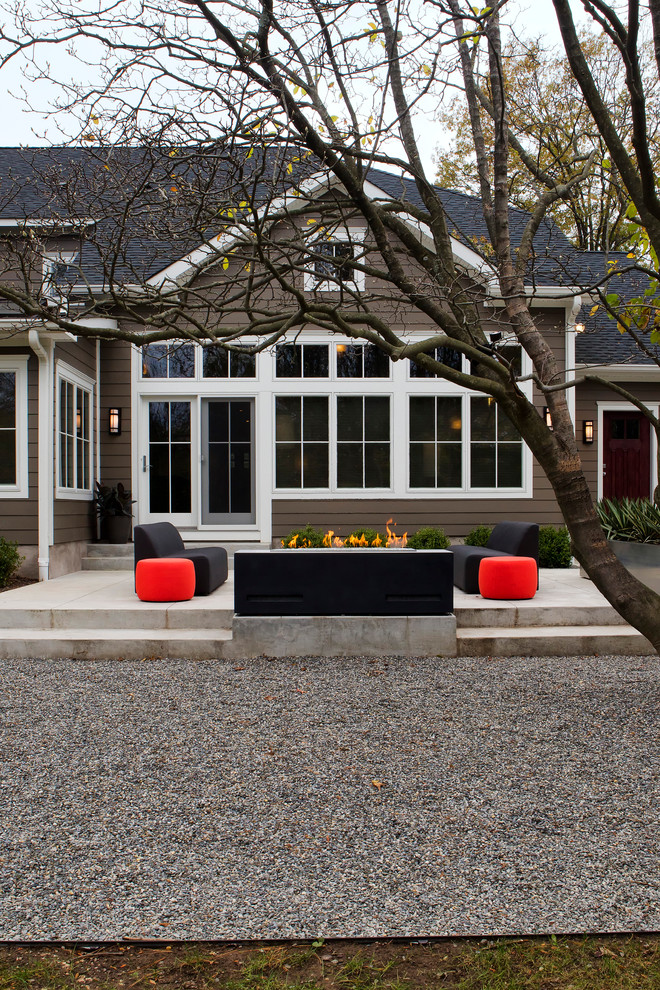 Diseño de patio contemporáneo grande sin cubierta en patio trasero con chimenea y gravilla