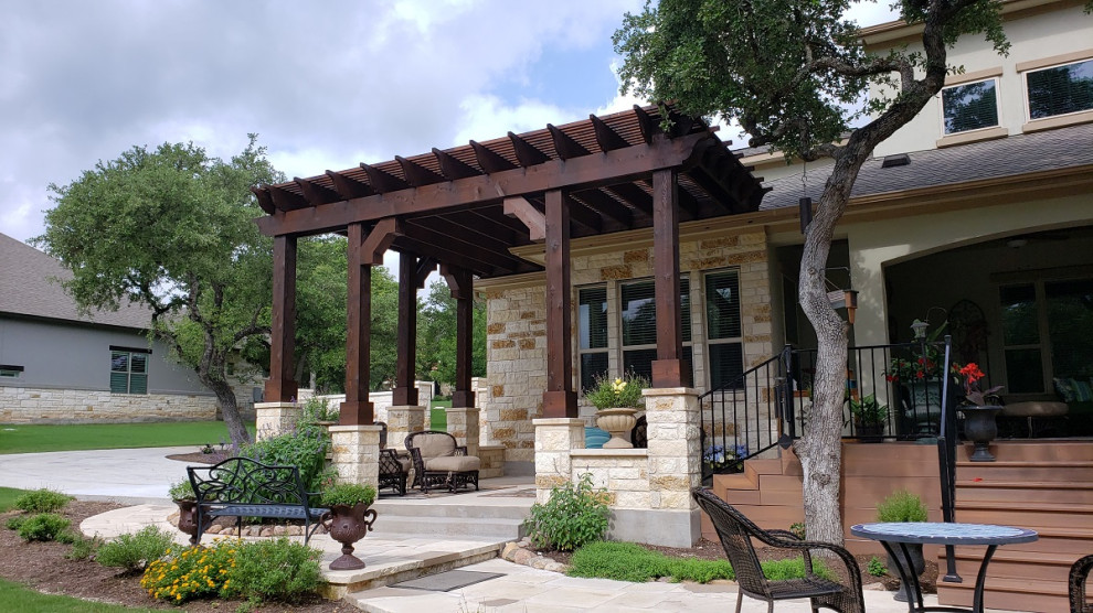 Example of a large mountain style patio design in Austin with a pergola