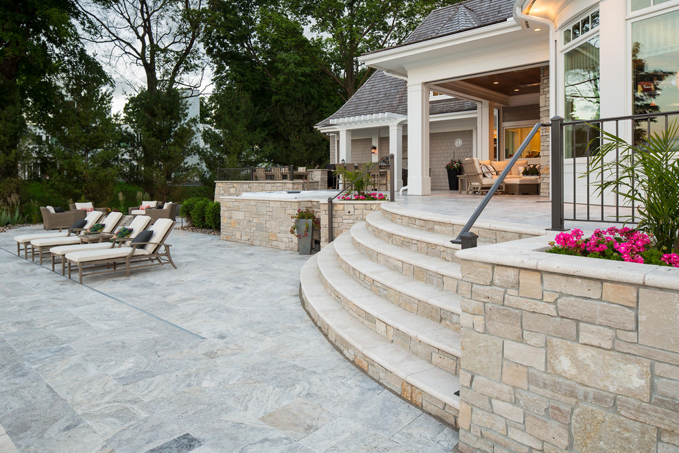 Cette image montre une grande terrasse arrière design avec des pavés en béton.