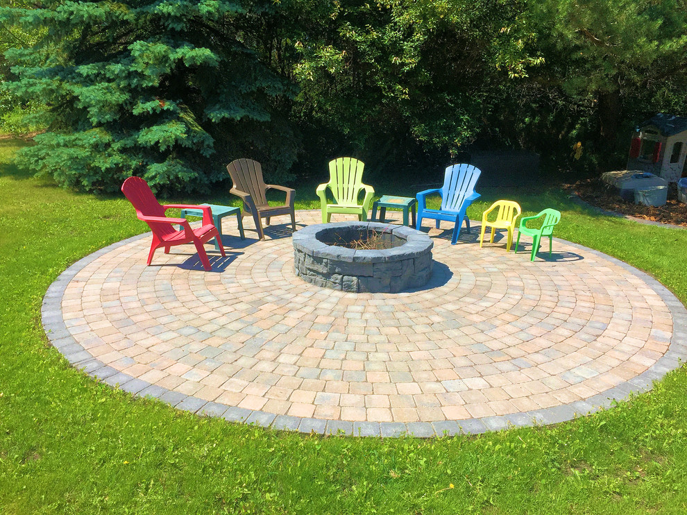 Example of a huge farmhouse backyard concrete paver patio design in Edmonton with a fire pit