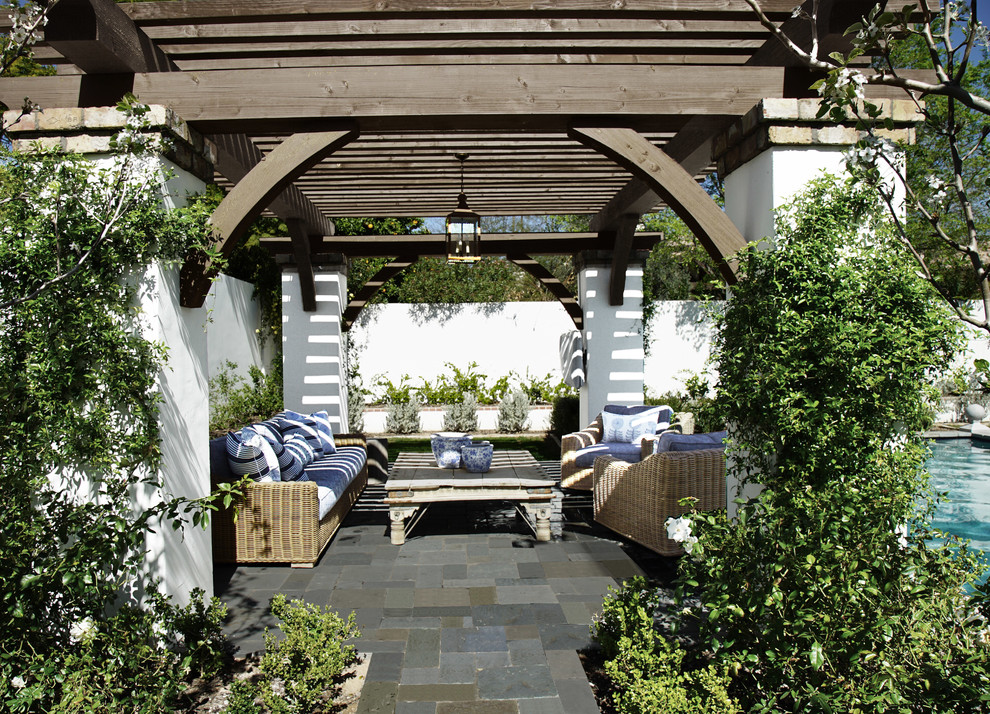 Immagine di un grande patio o portico chic dietro casa con un caminetto, pavimentazioni in mattoni e un gazebo o capanno