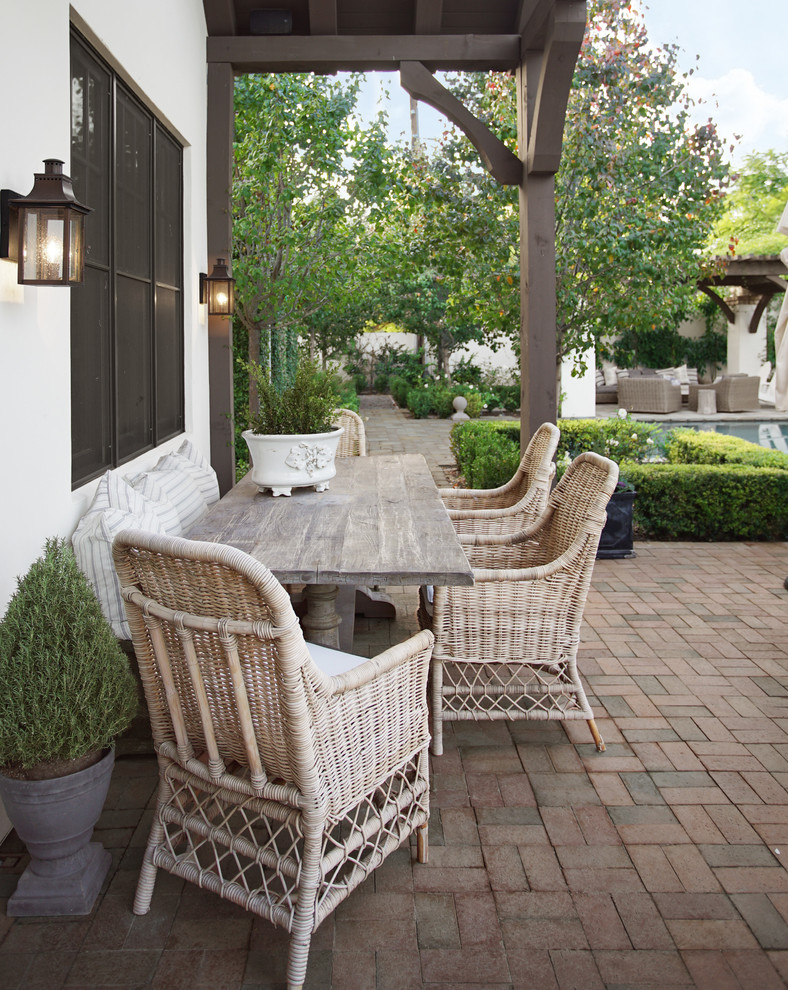 Example of a large classic backyard brick patio kitchen design in Phoenix with a roof extension