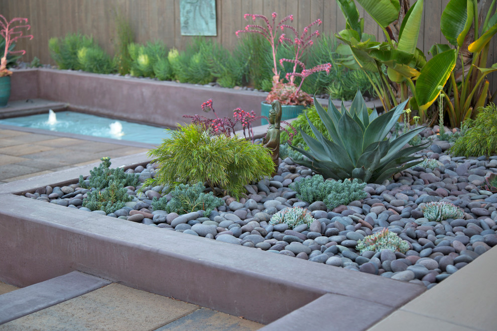 Photo of a small tropical backyard concrete paver water fountain landscape in San Luis Obispo.