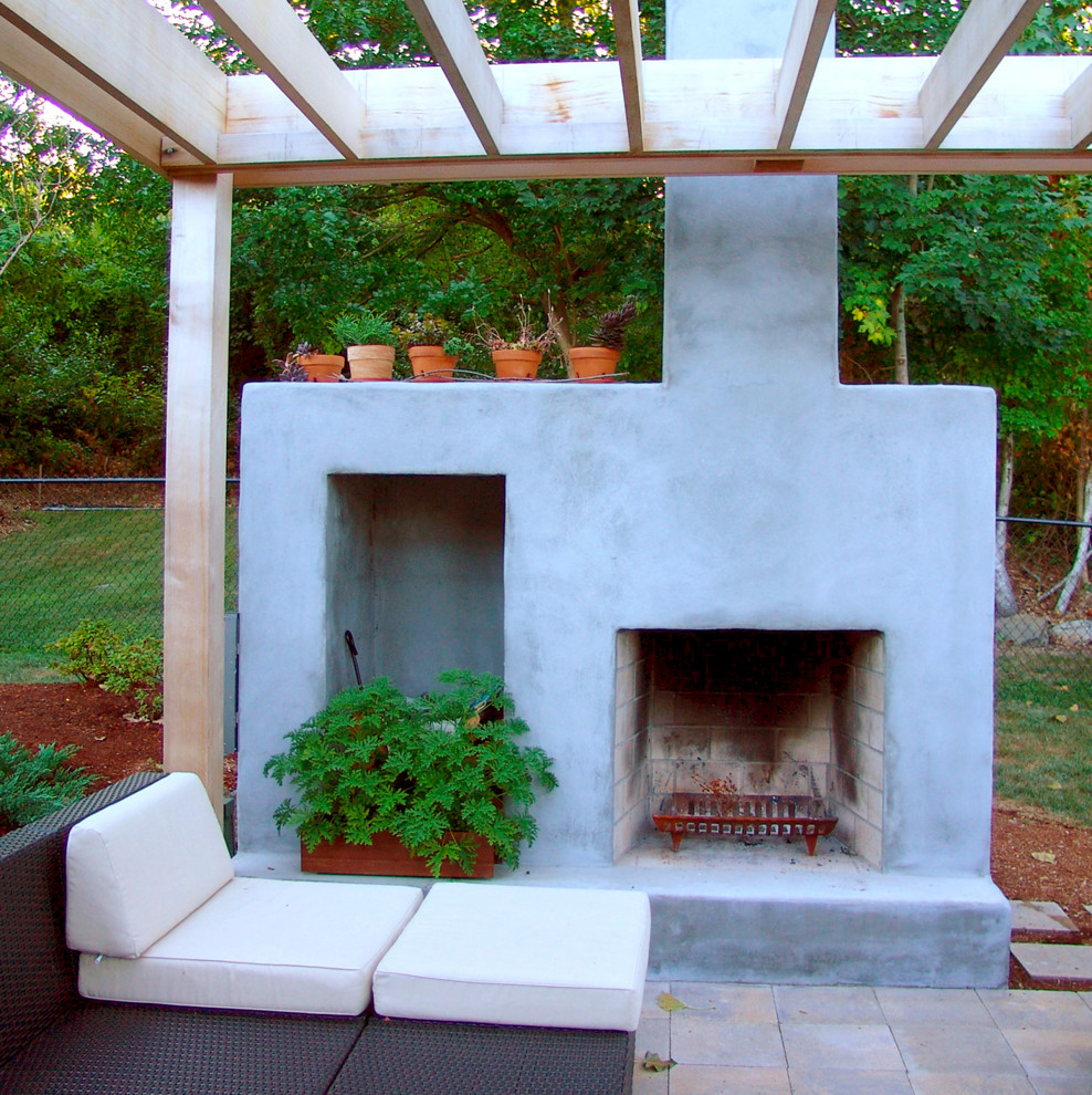 Aménagement d'une petite terrasse arrière contemporaine avec une cheminée, des pavés en béton et une pergola.