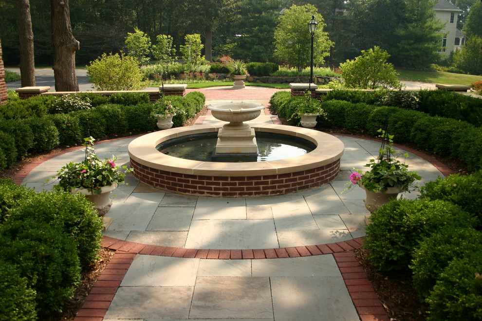 Example of a large classic courtyard stone patio fountain design in Chicago with no cover