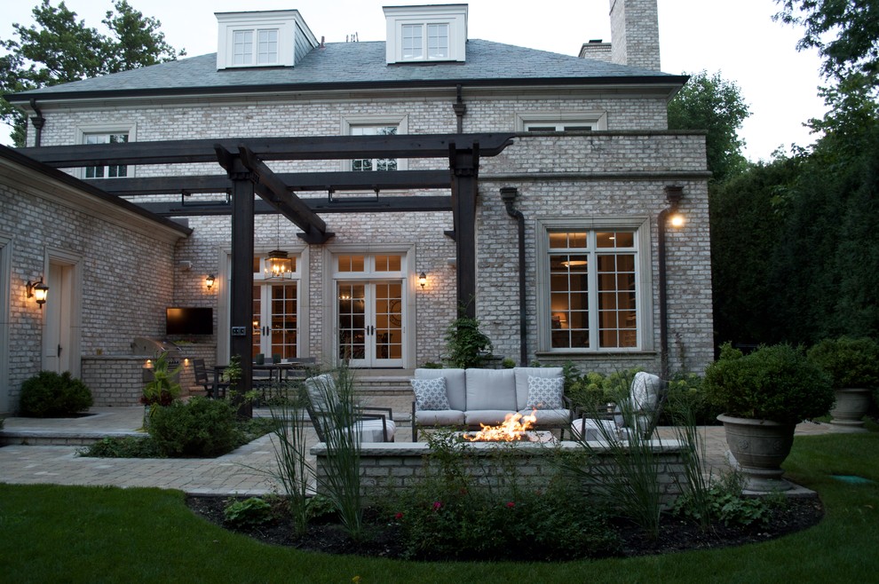 Diseño de patio clásico grande en patio trasero con cocina exterior, adoquines de piedra natural y pérgola