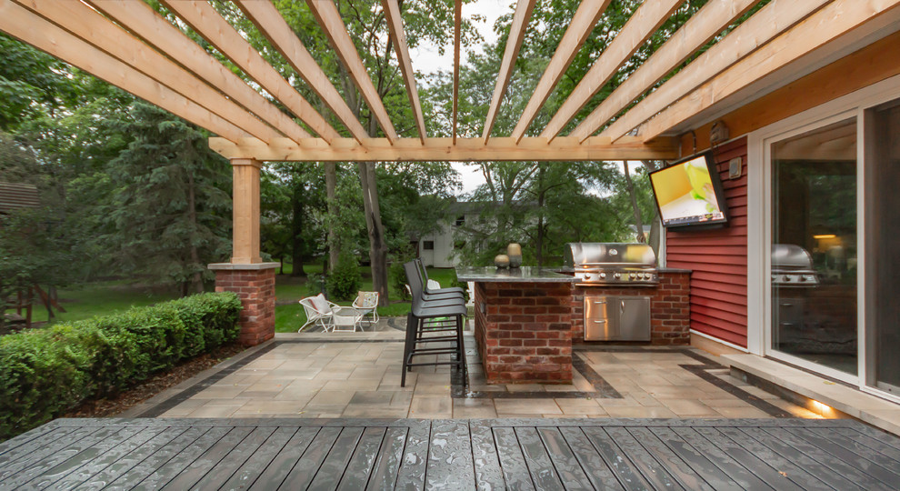 Réalisation d'une petite terrasse arrière craftsman avec une cuisine d'été, des pavés en brique et une pergola.